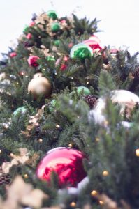 A towering holiday tree with red, green, silver, and gold bulbs.