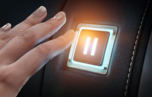 Close up of hand pushing glowing blue pause button. Image licensed through Adobe Stock.