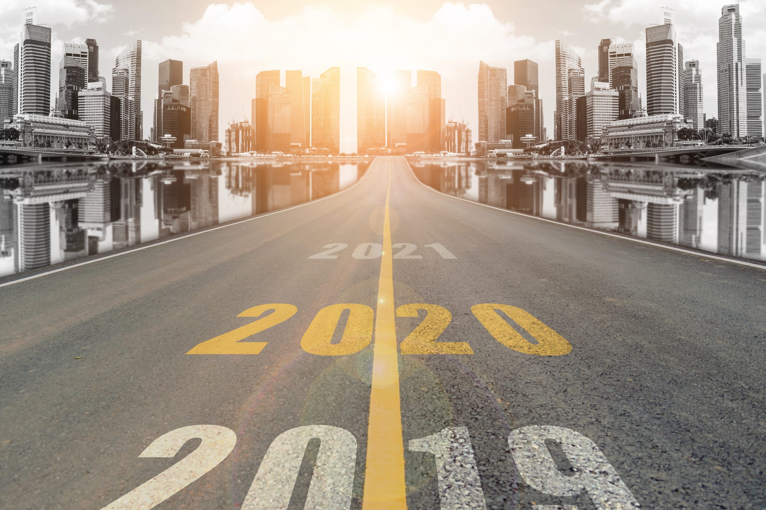 Lane blacktop in the colorful city with beautiful skyscrapers background. The years in large numbers proceed before the viewer, highlighting 2020. Image licensed through Adobe Stock.