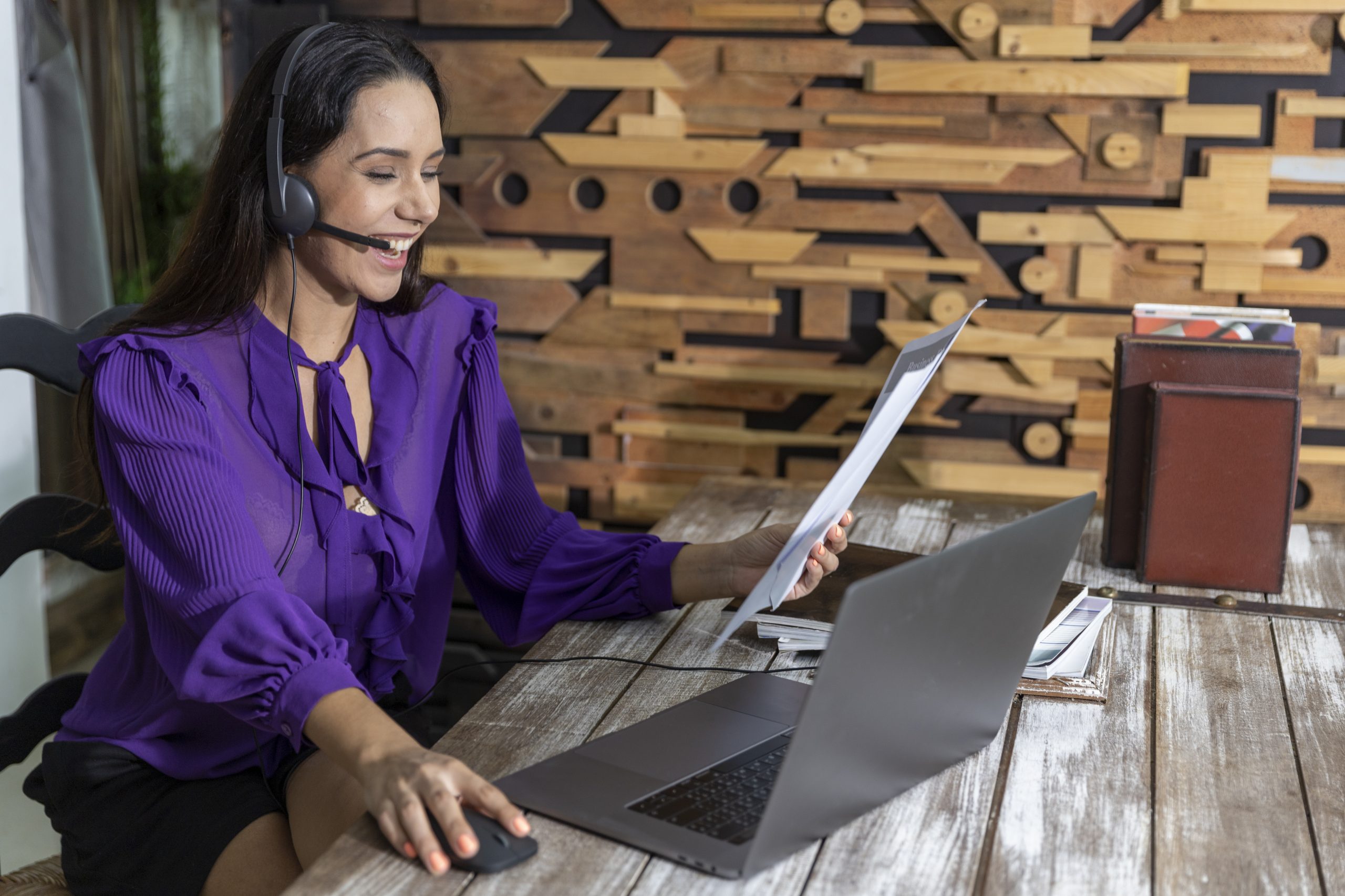 Young business woman in formal dress using headset to have teleconference with her colleagues during quarantine. Image licensed from Adobe Stock.