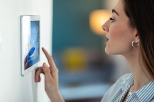 Shot of young using the home automation system on digital tablet to regulate the temperature. Image licensed through Adobe Stock.