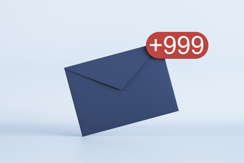 Full email box, depicted with a dark blue paper envelope with white +999 icon in red circle on the corner on light background. Image licensed through Adobe Stock.